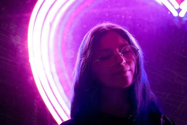 Model lit by colorful neon light with playful expression